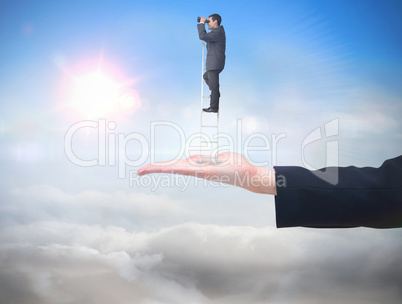 Composite image of businessman standing on ladder