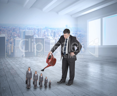 Composite image of mature businessman watering tiny businesswoma
