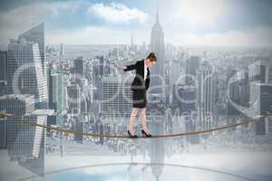 Composite image of businesswoman performing a balancing act on t