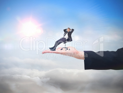 Composite image of businessman relaxing in swivel chair