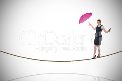 Composite image of pretty redhead businesswoman holding umbrella