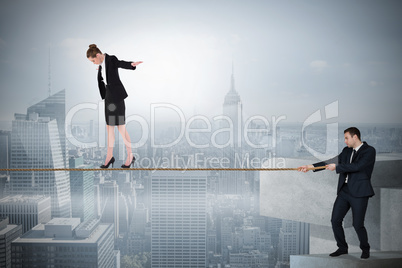Young businessman pulling a tightrope for business woman