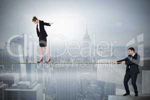 Young businessman pulling a tightrope for business woman
