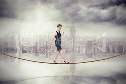 Composite image of businesswoman doing a balancing act on tightr