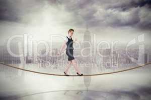 Composite image of businesswoman doing a balancing act on tightr