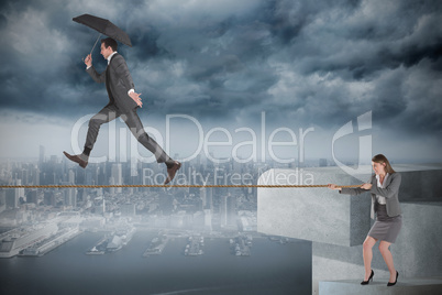 Young businesswoman pulling a tightrope for businessman