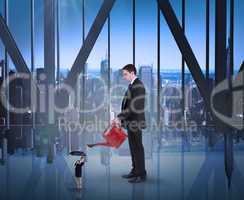 Composite image of businessman watering tiny businesswoman