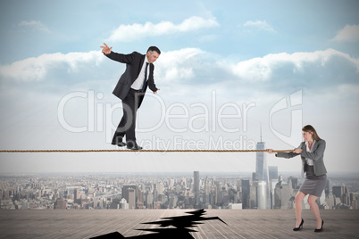 Young businesswoman pulling a tightrope for businessman