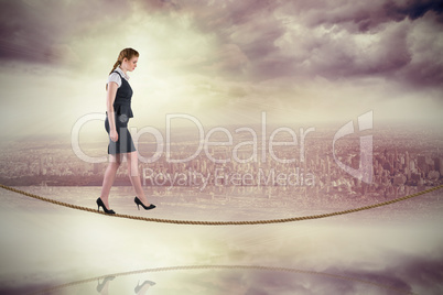 Composite image of redhead businesswoman stepping on tightrope