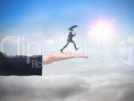 Composite image of businessman jumping holding an umbrella