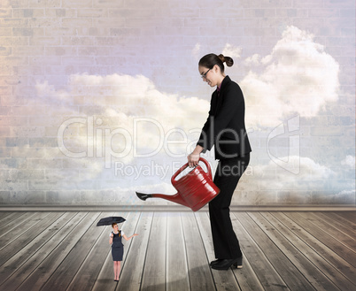Composite image of businesswoman watering tiny businesswoman