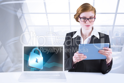 Composite image of redhead businesswoman using her tablet pc