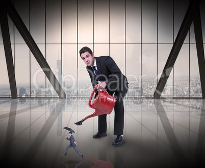 Composite image of businessman watering tiny businessman