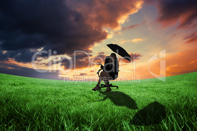 Composite image of young businesswoman holding umbrella