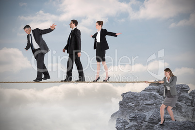 Young businesswoman pulling a tightrope for business people