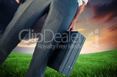 Composite image of businessman holding briefcase