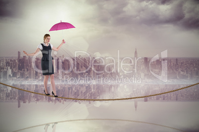 Composite image of pretty redhead businesswoman holding umbrella