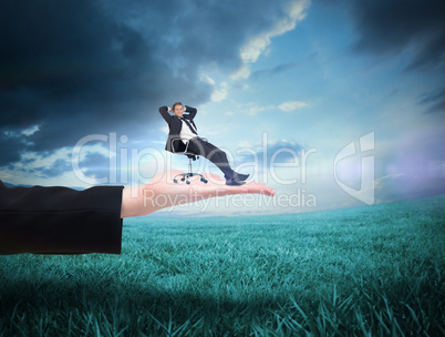 Composite image of businessman relaxing in swivel chair