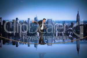 Composite image of mature businessman doing a balancing act on t