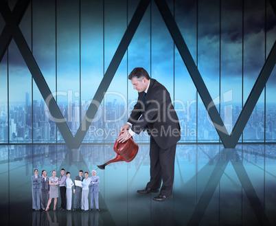 Composite image of mature businessman watering tiny business tea