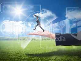 Composite image of businessman jumping holding an umbrella