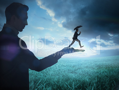 Composite image of businessman holding business man jumping