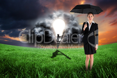 Composite image of young businesswoman holding umbrella