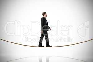 Composite image of handsome businessman stepping on tightrope