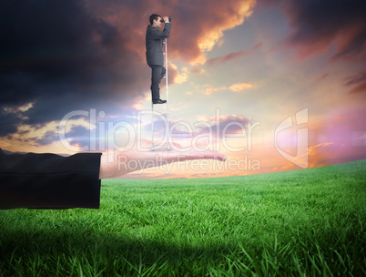 Composite image of businessman standing on ladder