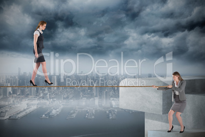 Young businesswoman pulling a tightrope for business woman