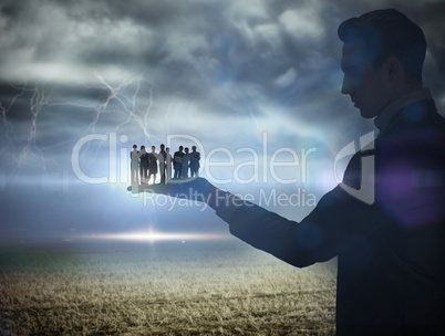 Composite image of businessman holding business team