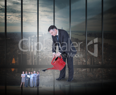 Composite image of mature businessman watering tiny business tea