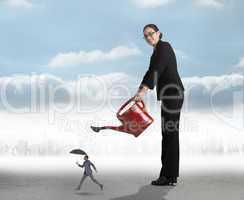 Composite image of businesswoman watering tiny business man