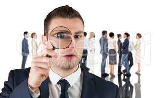 Composite image of businessman looking through magnifying glass