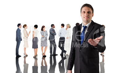 Composite image of handsome businessman holding hand out