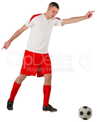 Fit football player playing with ball