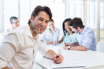 Attractive businessman smiling in the workplace