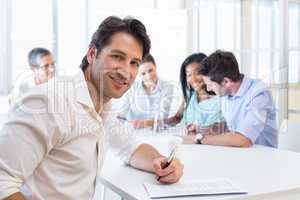 Attractive businessman smiling in the workplace