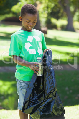 Young boy in recycling tshirt picking up trash