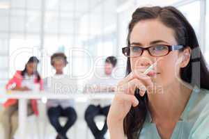 Attractive casual businesswoman holding pencil focusing