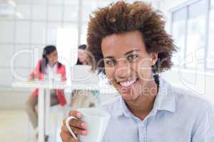 Businessman relaxing with coworkers behind him