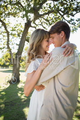 Smiling young couple embracing in park