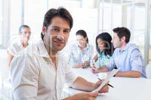 Attractive businessman smiling in the workplace