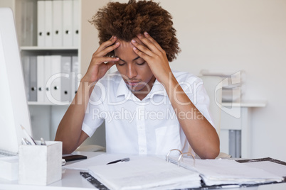 Casual stressed businessman with his head down at desk