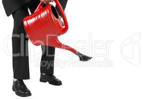 Businessman watering with red can