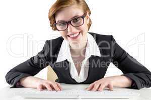 Redhead businesswoman sitting at desk typing