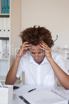 Casual stressed businessman with his head down at desk