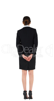 Businesswoman in suit standing with hands behind back