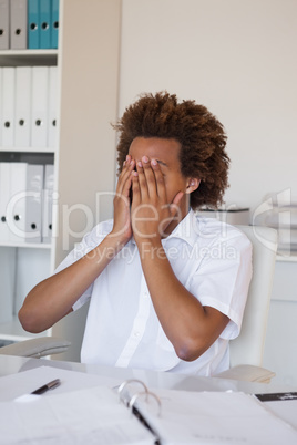 Casual stressed businessman covering face with hands