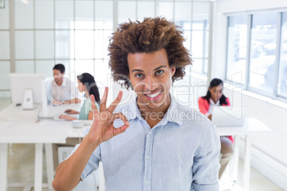 Businessman giving OK gesture to camera